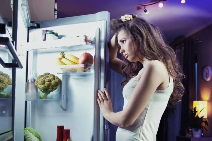 meitene pie ledusskapja, ievērojot savu iecienītāko diētu